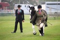 Guildford, England - May 28 2018: Equestrian competitor in a county show, being watched by a critical judge while she runs with h