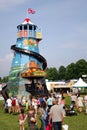 Guildford, England - May 28 2018: People walking towards a traditional old fashioned vintage Helter Skelter fairground slide on Royalty Free Stock Photo