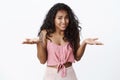 Guilty cute awkward african-american curly-haired female in pink cropped top, shrugging hands spread sideways