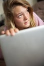 Guilty Looking Teenage Girl Using Laptop At Home