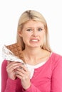 Guilty Looking Young Woman Eating Chocolateo