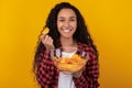 Excited Latin Lady Eating Delicious Potato Crisps