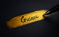 Guinea Handwriting Text on Golden Paint Brush Stroke