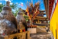 Guishan Dafo temple view with steaming offering burning and prayer flags Dharma wheel in background in Dukezong old town Shangri-
