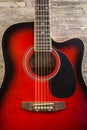 Guitar acoustic red, neck lying on a vintage background of wood on the background of old grunge boards. View Royalty Free Stock Photo