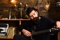 Guitar as hobby. Guy in cozy warm atmosphere play favourite music. Man with beard holds black electric guitar. Man Royalty Free Stock Photo