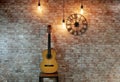 Guitar on the background of a brick wall. Watches and lamps, loft