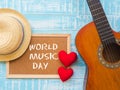 The guitar, board with WORLD MUSIC DAY text, red heart and hat