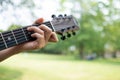 guitar chord played outdoors in a park with trees as background