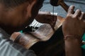 A guitar craftsman are carving a classical guitars made from wood, with Balinese pattern, in a wooden guitar workshop at Guwang