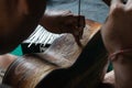 A guitar craftsman are carving a classical guitars made from wood, with Balinese pattern, in a wooden guitar workshop at Guwang