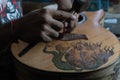 A guitar craftsman is measuring and make sure it is precision in a wooden guitar workshop in Guwang Village, Gianyar, Bali. This