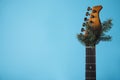 Guitar with fir tree branch on light blue background, space for text. Christmas music Royalty Free Stock Photo