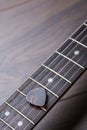 Guitar frets with strings and mediator on dark brown surface Royalty Free Stock Photo