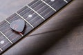 Guitar frets with strings and mediator on dark brown table Royalty Free Stock Photo