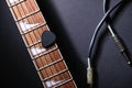 Guitar frets with strings and mediator, jack cable on dark Royalty Free Stock Photo