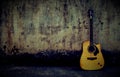 An acoustic guitar in a vintage style showcased towards the wall with copy space Royalty Free Stock Photo