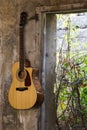 Guitar hanged on the wall in the broken house