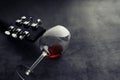 Guitar and high glass with red wine on a stone background