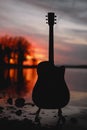 Guitar by the lake at sunset time Royalty Free Stock Photo