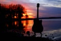 Guitar by the lake at sunset time Royalty Free Stock Photo