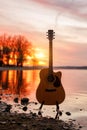 Guitar by the lake at sunset time Royalty Free Stock Photo