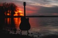 Guitar by the lake at sunset time Royalty Free Stock Photo