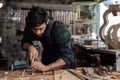 guitar luthier using chisel to shave bracing of acoustic guitar