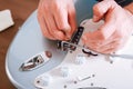 Guitar master making professional guitar maintenance, hands with tools close up. Guitar technician repairing and