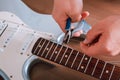 Guitar master restringing electric guitar, top view, closeup