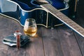 Guitar, money and whiskey on wooden table Royalty Free Stock Photo