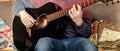 Guitar music lessons at home concept. fingers on a guitar to play arpeggios. Man hands playing black acoustic guitar, wide photo