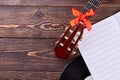 Guitar and music sheets on wooden background. Royalty Free Stock Photo