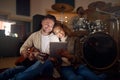 Guitar, musician couple and tablet in studio for music production or social media. Musicians, diversity love and happy