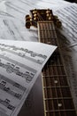 Guitar neck, stretched guitar strings and musical notation.