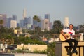 Guitar player on rooftop with Los Angeles skyline in background Royalty Free Stock Photo