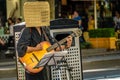 Guitar player in the street with a basket on the head Royalty Free Stock Photo