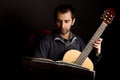 Guitar player studying with music stand