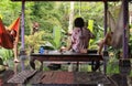 Guitar plays relaxing tunes and two people listening in hammock under bale, in Ubud