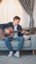 Guitar practice online course man laptop home Royalty Free Stock Photo