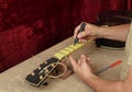 Guitar repair and service - Worker preparation of frets for grin