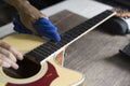 Guitar repairer is cleaning acoustic guitar