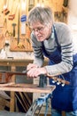 Guitar repairer filing the frets of an acoustic guitar