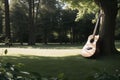 A guitar resting against a tree in a meadow Royalty Free Stock Photo