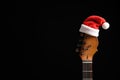 Guitar with Santa hat on black background