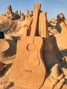 Guitar sculpted in sand, a summer day