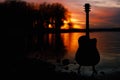 Guitar by the lake at sunset time Royalty Free Stock Photo