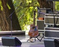 A guitar is sitting on a stand in front of a microphone Royalty Free Stock Photo