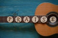 Guitar on teal wood with the word: PRAISE Royalty Free Stock Photo