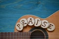 Guitar on teal wood with the word: PRAISE Royalty Free Stock Photo